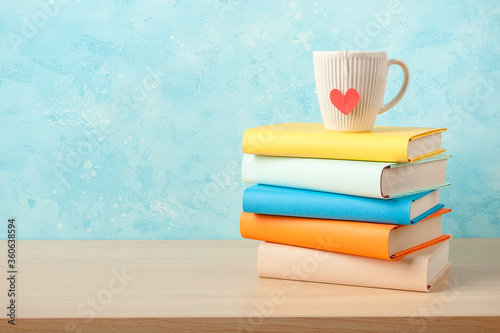 Stack of books and mug on wooden table