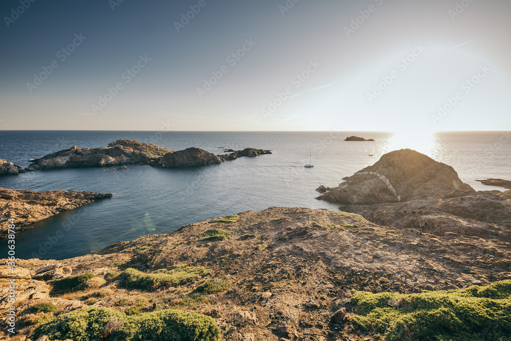 A rocky shore next to a body of water A rocky shore next to a body of water