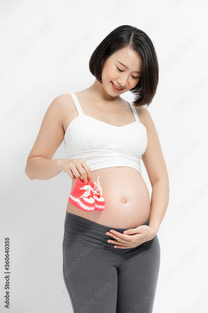 Pregnant woman holding small baby socks Pregnant woman holding small baby socks