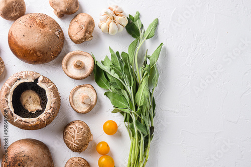 Mushrooms ingredients for baking portobello, cheddar cheese, cherry tomatoes and sage  on white background top view space for text.