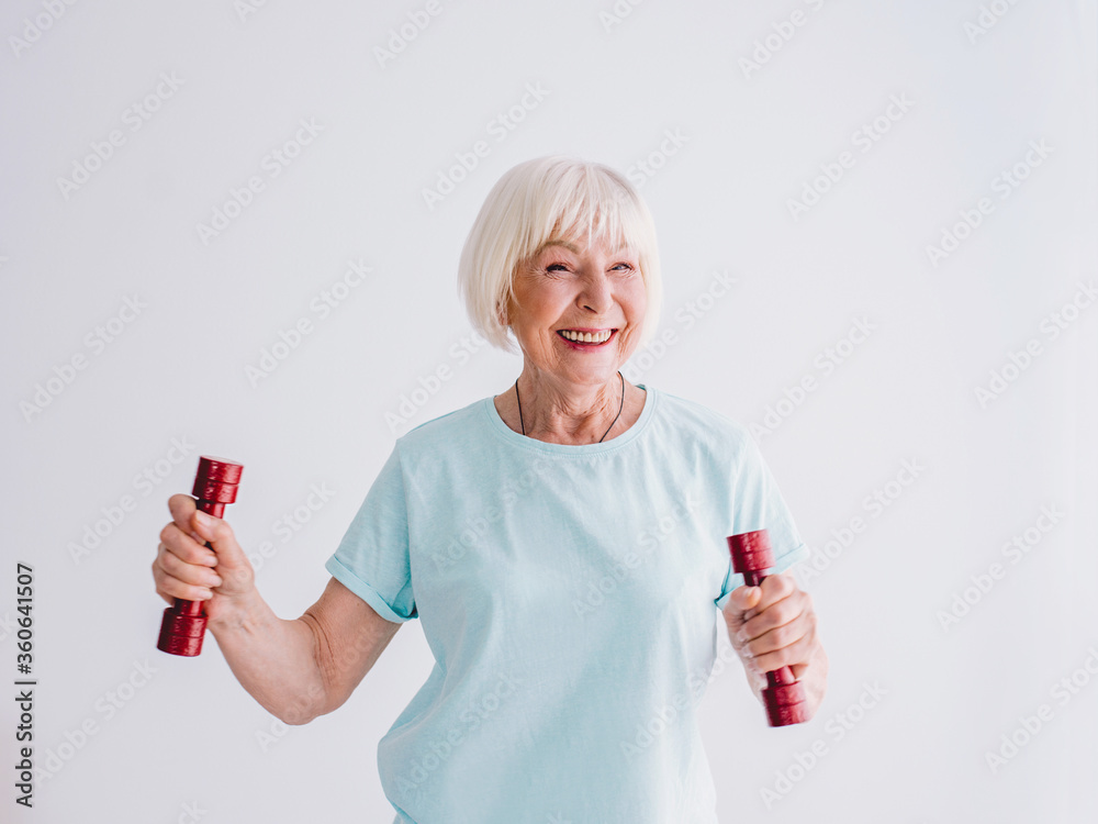 old cheerful woman doing sports with dumbbells. Anti age, sports, healthy life style concept old cheerful woman doing sports with dumbbells. Anti age, sports, healthy life style concept