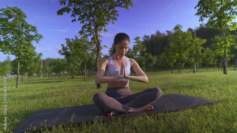 Young woman yoga outdoors keep calm and meditates while practicing yoga to explore the inner peace. Young woman yoga outdoors keep calm and meditates while practicing yoga to explore the inner peace.