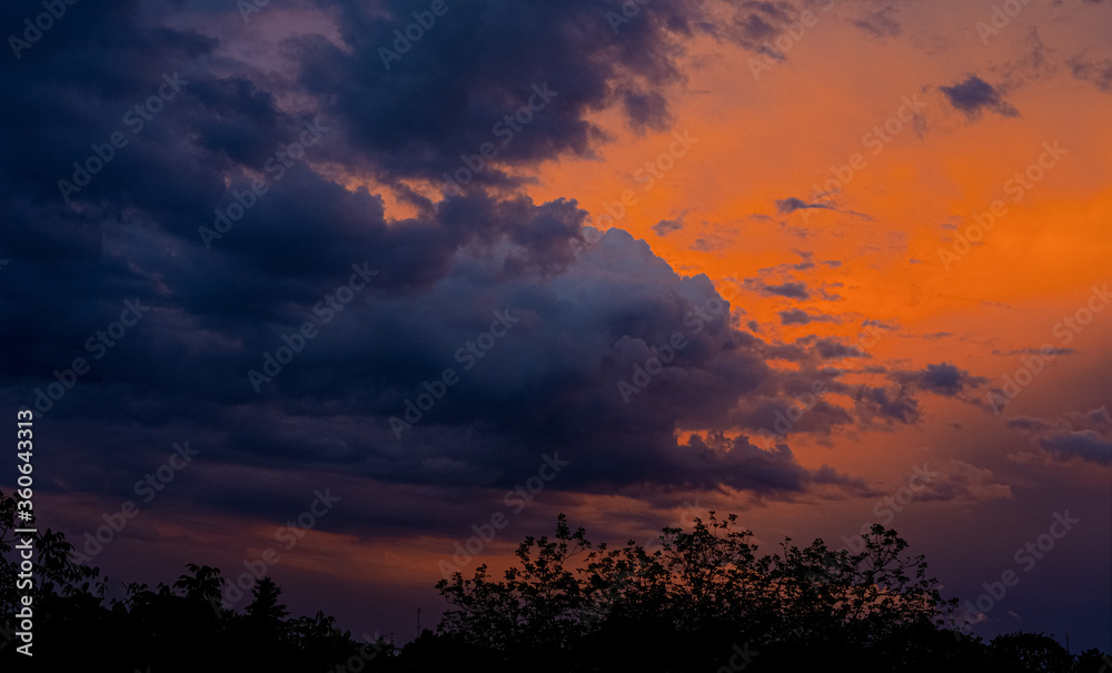 Naklejka premium Clouds under a crimson sky at sunset