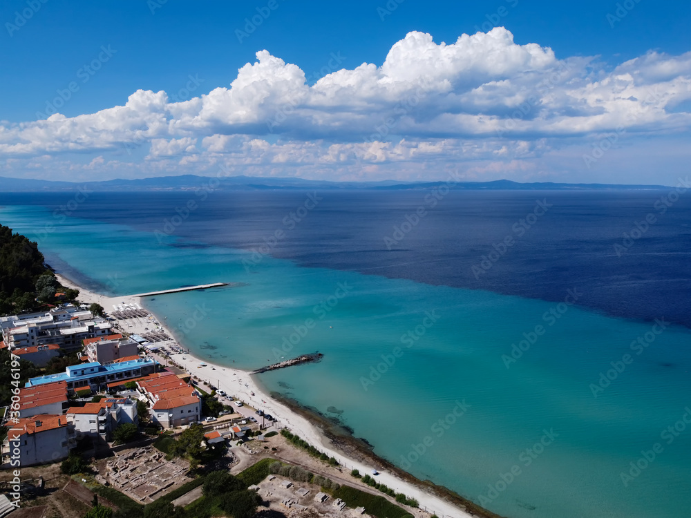 Chalkidiki, Greece coastal village landscape drone shot with seaside hotel. Aerial day view of Kallithea seafront at Kassandra peninsula with a beach bar by a clean tranquil blue sea.