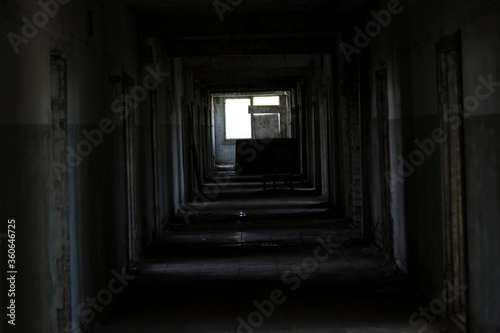 A dark corridor in an abandoned building. A cluttered corridor in ruins. Abandoned building. Horror. Dark room. Long passage.
