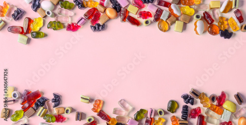 Colorful candy on pink background. Chewing sweets on light table. Top view, flat lay, copy space, banner