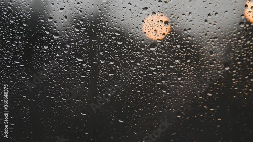 Raindrops dripping on the window glass after the storm.