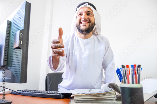 Arabic muslim manager standing to weclome his guest photo