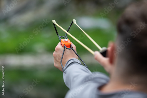 Bild auf Leinwand the man directed the slingshot forward to shoot