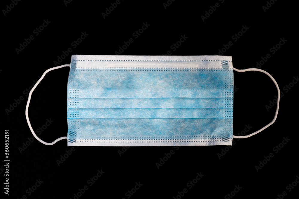 Medical mask holded by hands with a dark background Medical mask holded by hands with a dark background