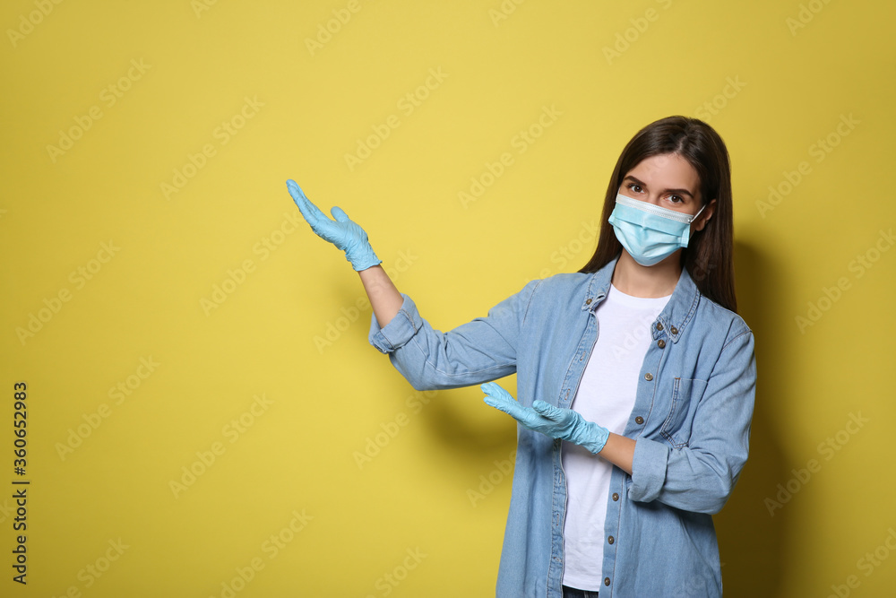 Female volunteer in mask and gloves on yellow background, space for text. Protective measures during coronavirus quarantine Female volunteer in mask and gloves on yellow background, space for text. Protective measures during coronavirus quarantine