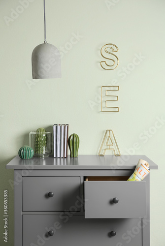 Grey chest of drawers near light wall in room © New Africa