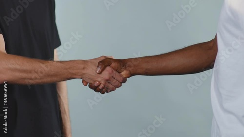 Hands white and black men shake hands stop racism all people are equal togetherness symbol tolerance multiracial peace interracial friendship anti-racism slow motion