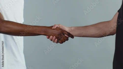Hands white and black men shake hands stop racism all people are equal togetherness symbol tolerance multiracial peace interracial friendship anti-racism slow motion