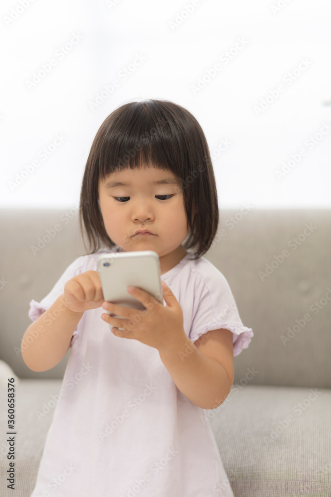 スマホを操作する3歳の子供