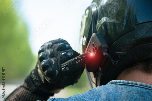 Photos Motorbiker is using a phone headset on his helmet close up.