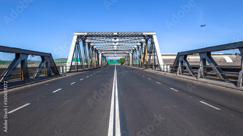 Fototapeta Naklejka Na Ścianę i Meble -  Dual Road Steel Iron Bridge New Asphalt Middle Perspective with blue sky.