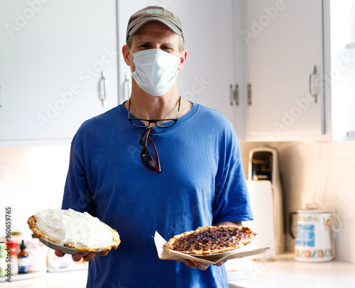 Man delivering pies at home wearing surgical mask