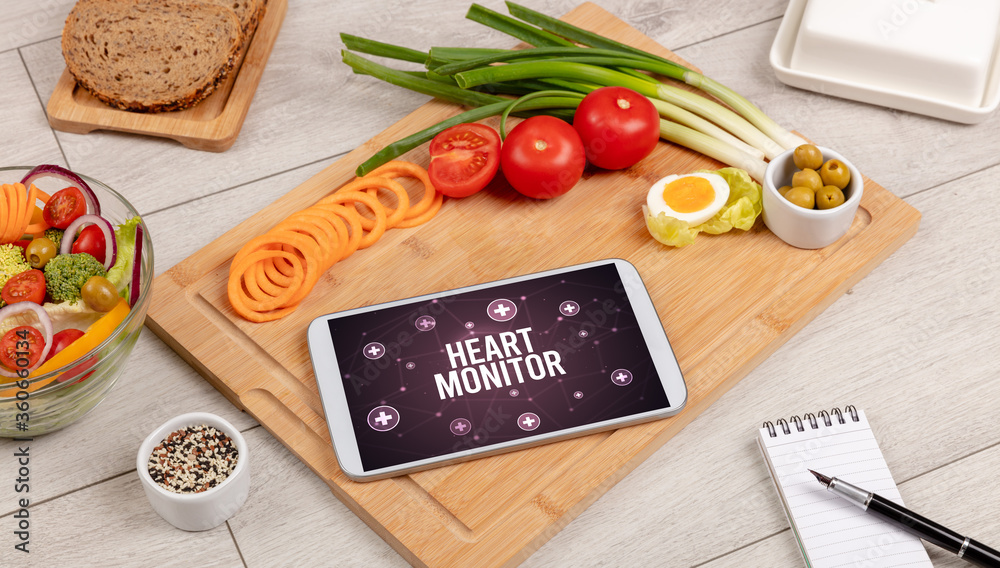 HEART MONITOR concept in tablet pc with healthy food around, top view HEART MONITOR concept in tablet pc with healthy food around, top view