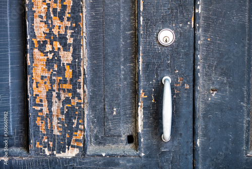 Peeling paint on old weathered door.