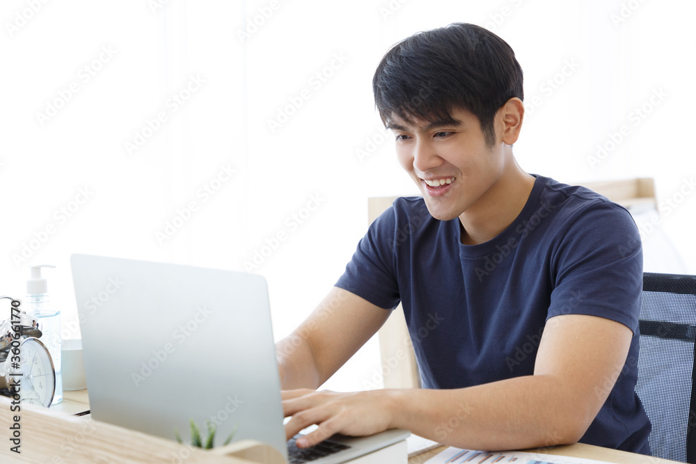 Happy man using Laptop computer and checking good News in the Bedroom. COPY SPACE. Trading. Working. WORK FROM HOME WFH Concept. Happy man using Laptop computer and checking good News in the Bedroom. COPY SPACE. Trading. Working. WORK FROM HOME WFH Concept.