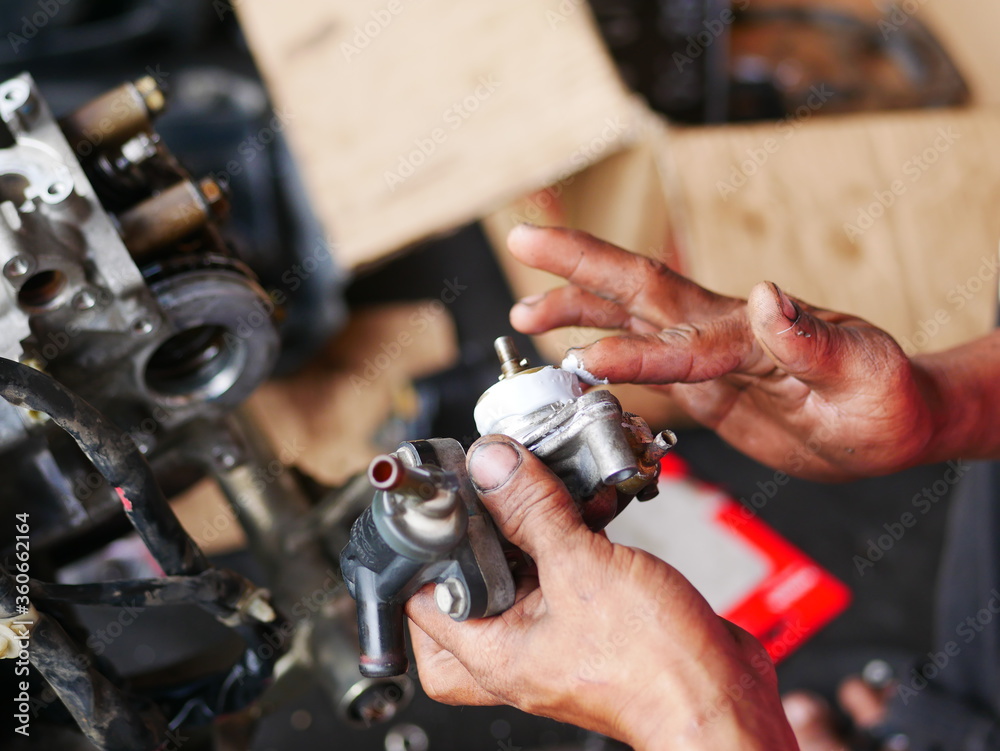 Mechanic working on motorcycle engine in workshop. Mechanic working on motorcycle engine in workshop.