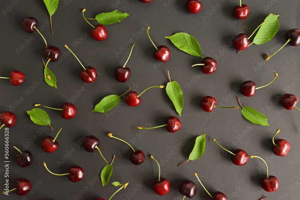 Cherry pattern. Flat lay of cherries on a dark blue background.Top view Cherry pattern. Flat lay of cherries on a dark blue background.Top view