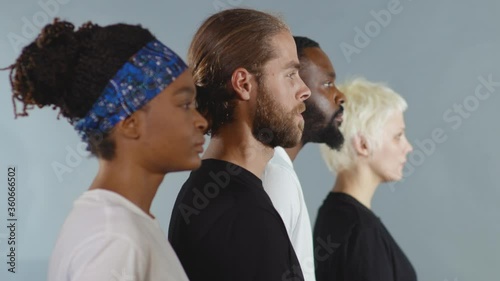Side shot of group of people of different races raise head black white man woman stop racism all people are equal togetherness multiracial peace interracial friendship anti-racism slow motion