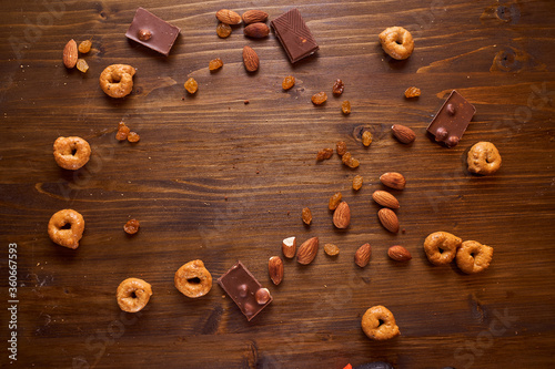 composition of chocolate, tartallini, nuts and raisins on a brown background. With copy space.