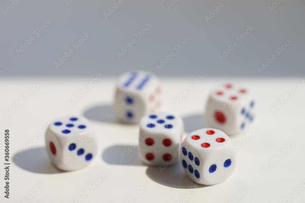Five dice with different numbers on a white sunny table Five dice with different numbers on a white sunny table