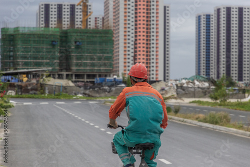 Obraz na plátně Construction worker riding a bicycle to work