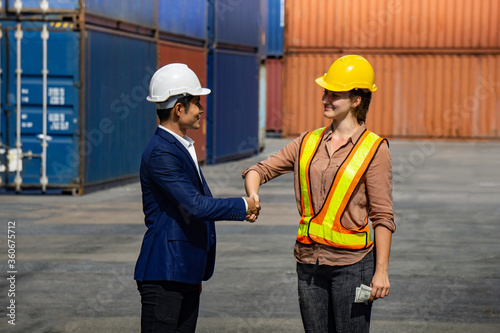 Business man and industrial worker woman shaking hands