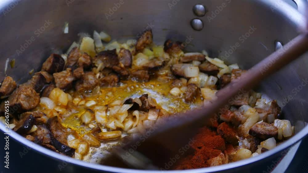 Cooking on oil onion, sausages and adding paprika powder Cooking on oil onion, sausages and adding paprika powder