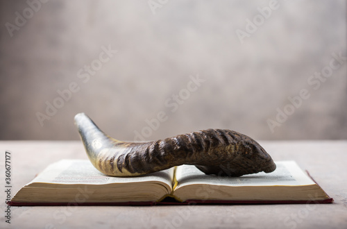 Rosh Hashanah (Hashana) (jewish New Year holiday) concept with Ram shofar (horn) with religious holy prayer book on table photo