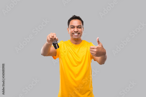 Indian Man Smilling Showing Thumb up and Car Keys Isolated. Driver