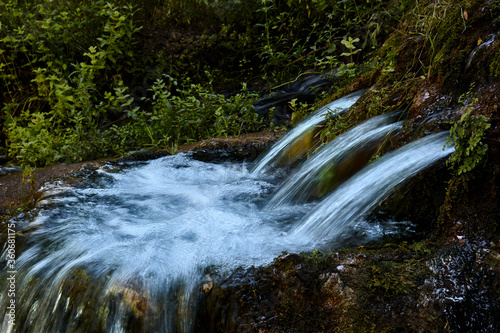 Fototapeta Naklejka Na Ścianę i Meble -  Fountain of three water pipes in the forest