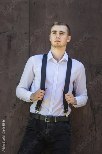 The guy in the shirt and suspenders. The guy stands on a background of wood, hands hold the suspenders