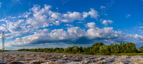 panorama with a rough river and cloudy sky