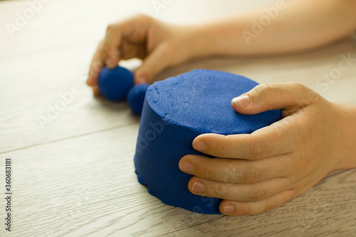 Child playing with kinetic sand.