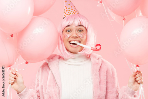 Canvas Print Young teenage girl wearing winter coat, birthday hat, wig, holding balloons and