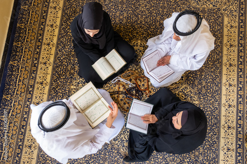 Top view of muslim family members reading quraan together