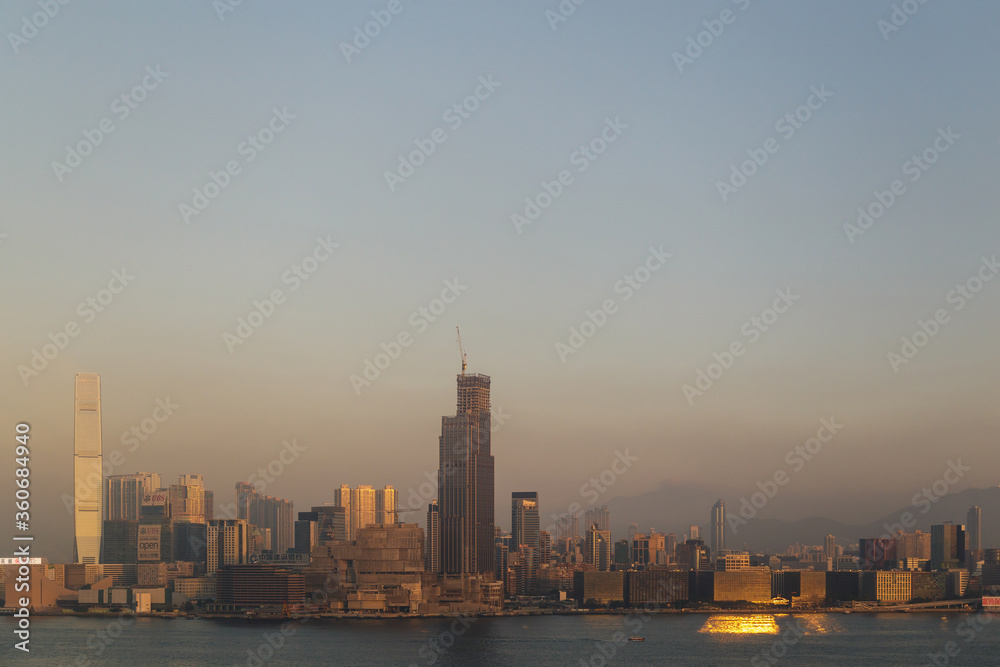 HONG KONG, CHINA - CIRCA 2020: Hong Kong Skyline and Victoria Harbor in morning. Sunset over Hong Kong bay on a clear day