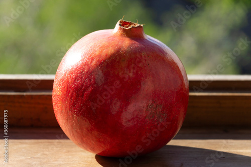 Obraz na płótnie Ripe pomegranate fruit on a wooden windowsill w salonie