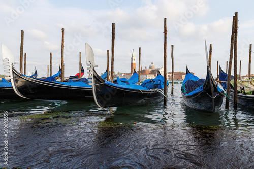 Venice, Italy - CIRCA 2020: View of empty gondolas on a water canal in Venice Italy. Concept of the effects of lock down due to CoronaVirus COVID-19. Picturesque landscape. © Ovidiu