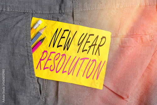 Word writing text New Year Resolution. Business photo showcasing listing of goals and change with determination Writing equipment and yellow note paper inside pocket of man work trousers