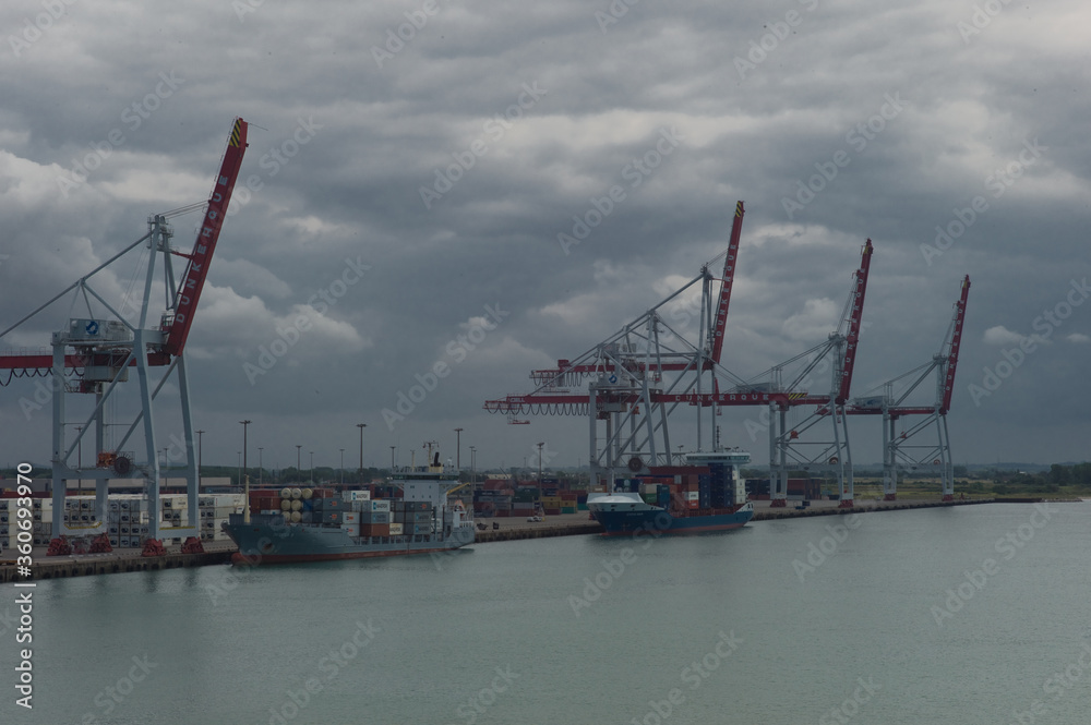 Fototapeta premium View at Dunkirk from the Canal between England and France on industry, cranks, container ships and port of Dunkirk in France