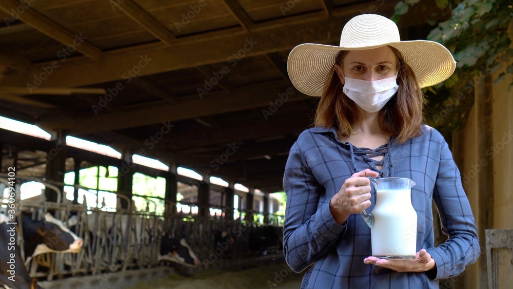 Farm open for business. Woman farmer in pandemic mask holding fresh milk. Dairy cows farm pandemic.