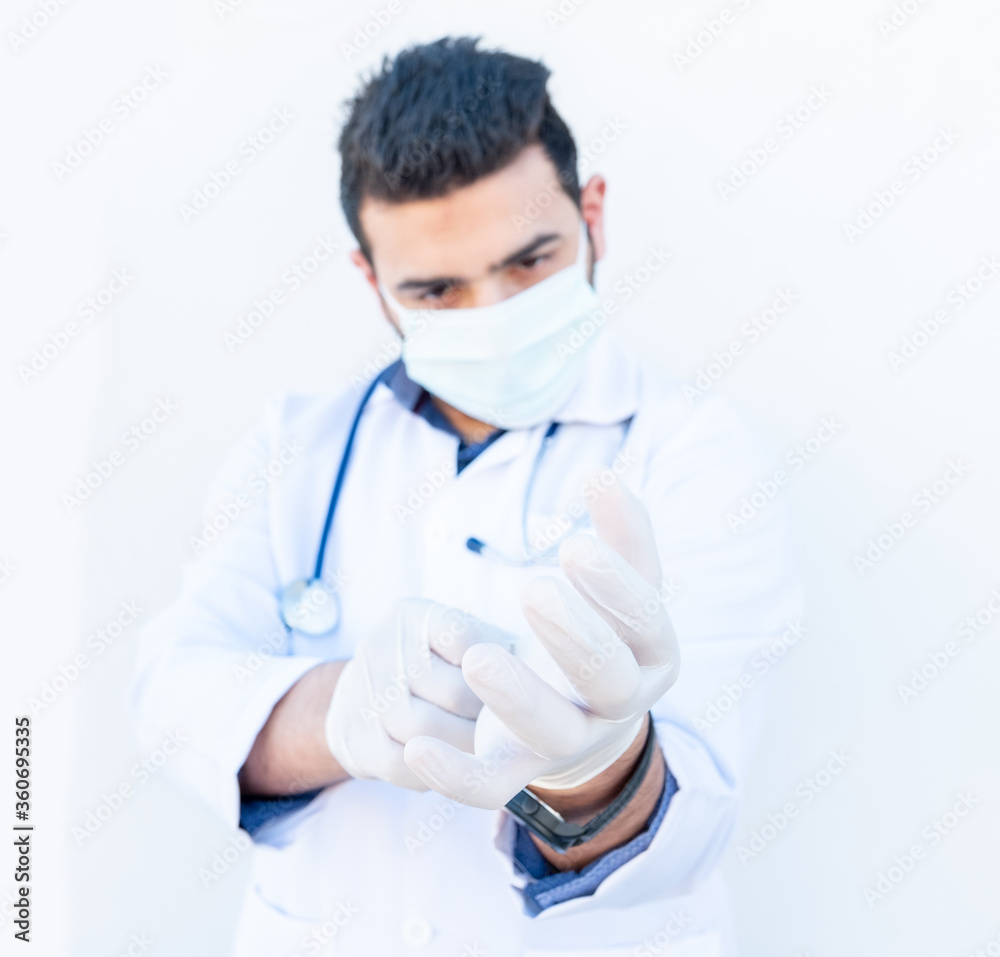 Arabic doctor wearing gloves to protect him self from infection Arabic doctor wearing gloves to protect him self from infection
