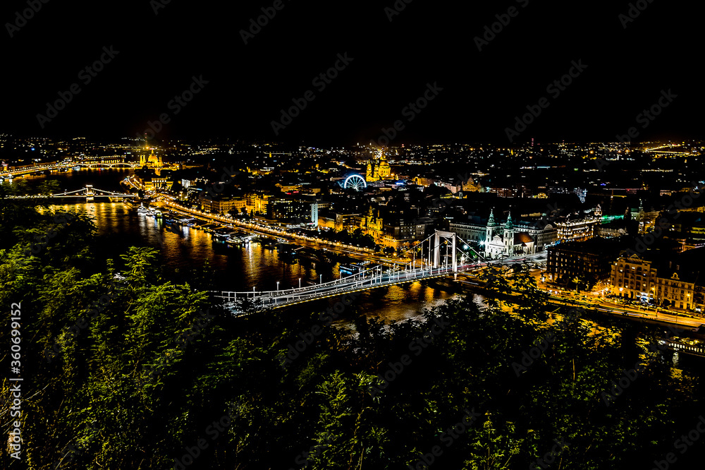 A view of the bridge over the River Danube from the foot of the Liberty Statue at night in the summertime