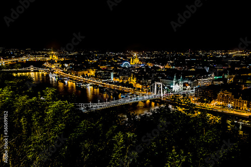A view of the bridge over the River Danube from the foot of the Liberty Statue at night in the summertime